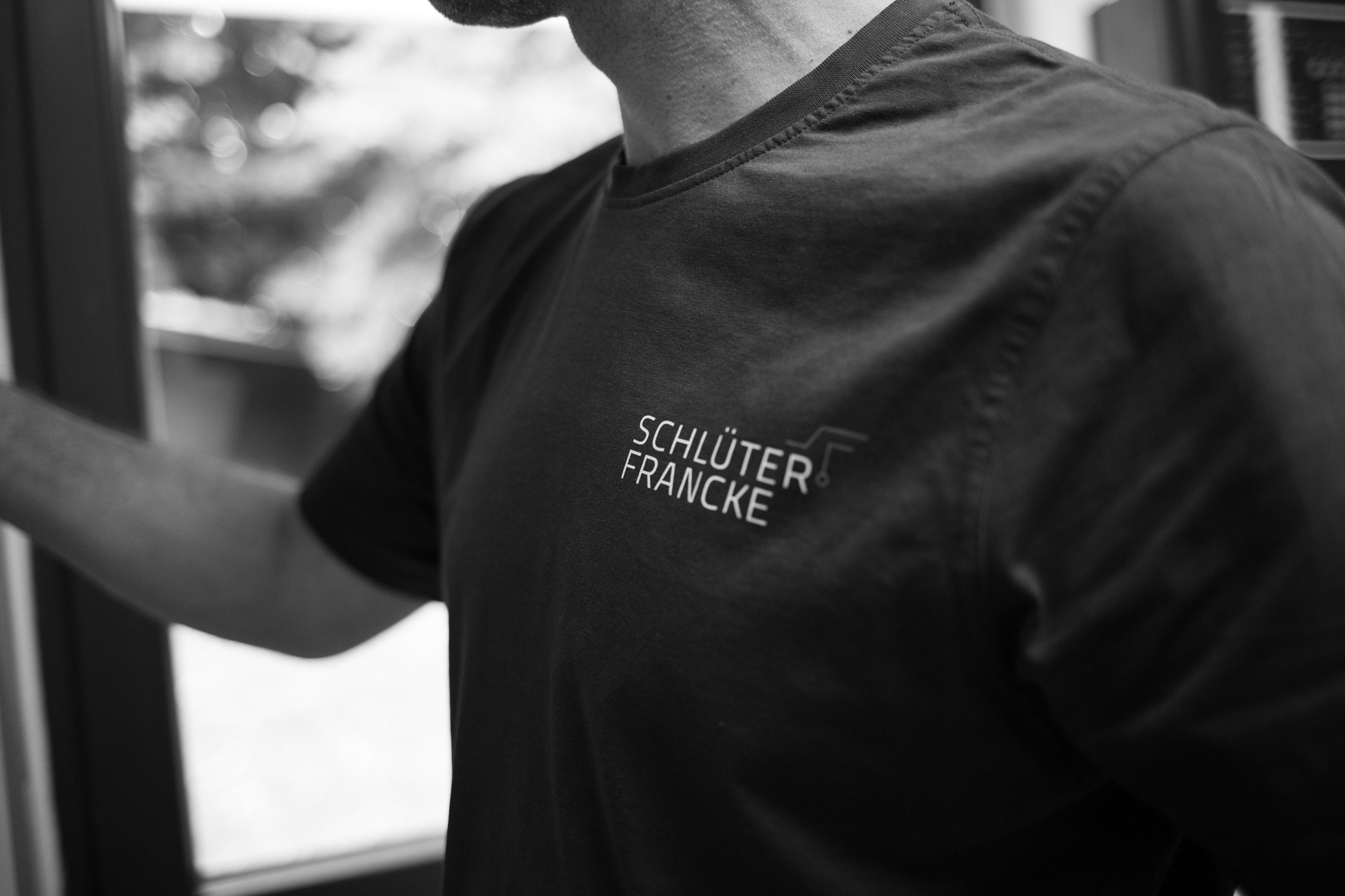 Blitzschutzprüfung in einem T-Shirt mit Schlüter & Francke Logo.